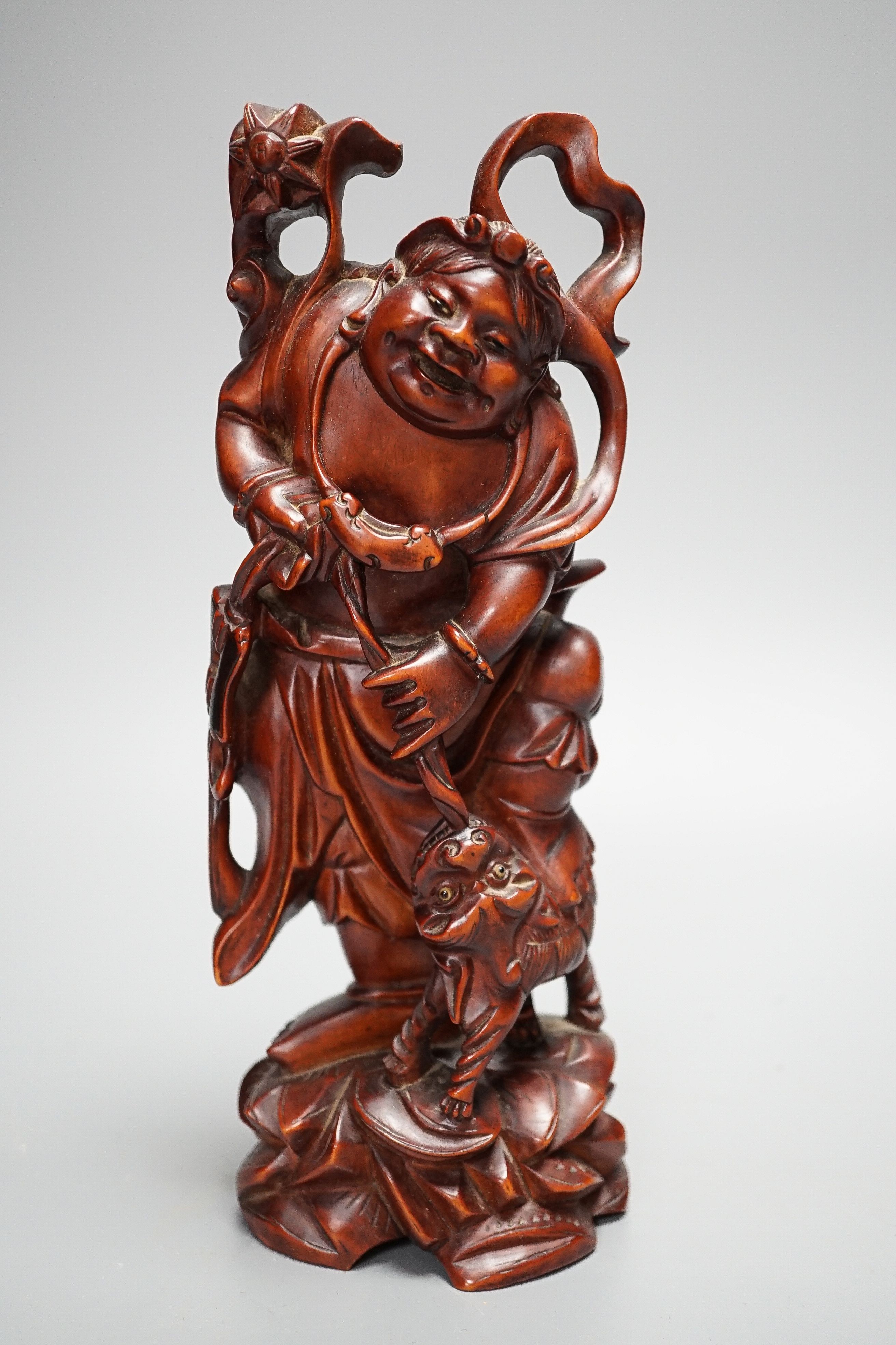 A Chinese carved cherrywood group of an immortal and a beast, early 20th century, height 24cm